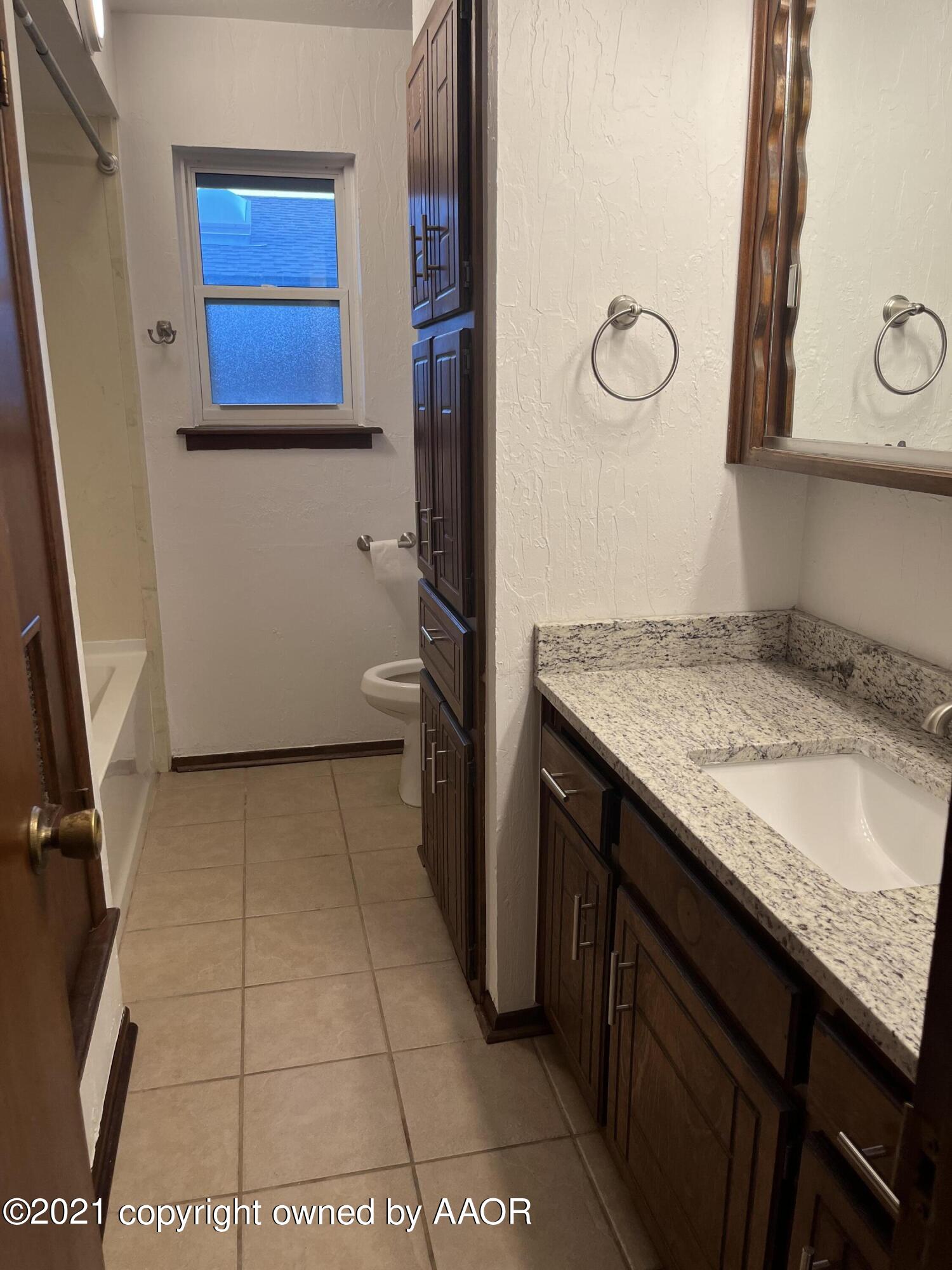 4308 Ridgecrest Circle Amarillo, TX 79109 - Photo 9 of 12 a bathroom with a granite countertop sink and a mirror