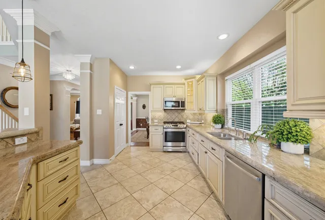 a kitchen with stainless steel appliances kitchen island granite countertop a refrigerator and a stove