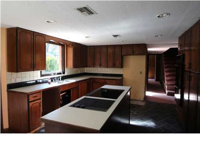 1500 Preservation Path Baker, FL 32531 - Photo 5 of 20 a kitchen with stainless steel appliances kitchen island granite countertop a refrigerator a sink and wooden cabinets