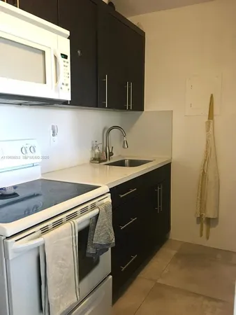 a kitchen with a sink stove and microwave