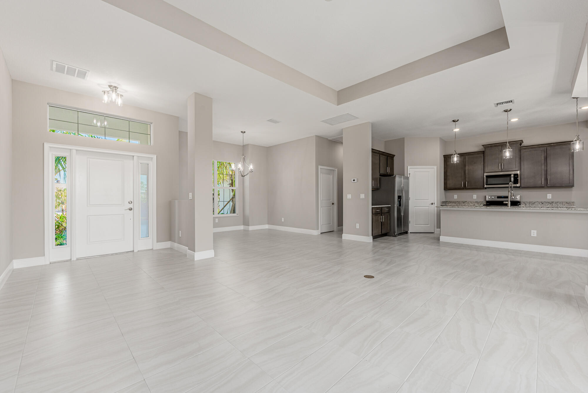 3972 Southeast Fairway West Stuart, FL 34997 - Photo 19 of 52 a view of an empty room and kitchen with furniture wooden floor and a window