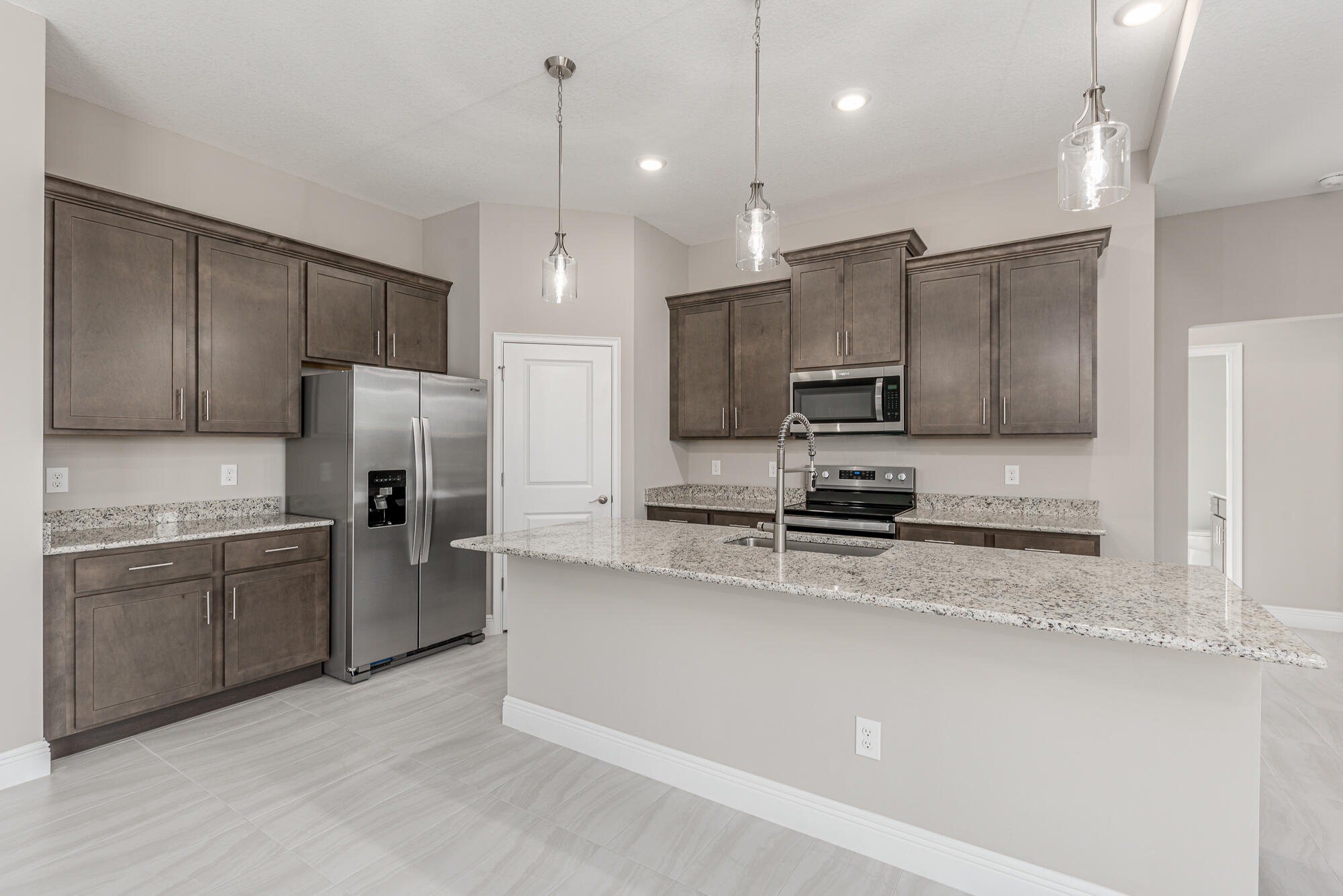 3972 Southeast Fairway West Stuart, FL 34997 - Photo 23 of 52 a kitchen with stainless steel appliances granite countertop a refrigerator a stove a sink and a microwave