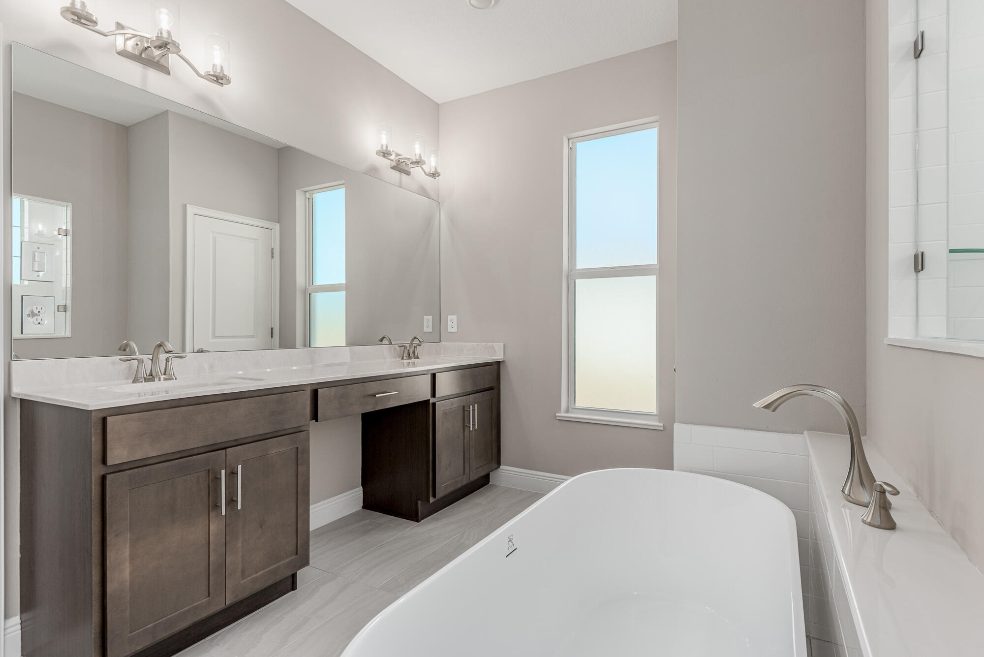 3972 Southeast Fairway West Stuart, FL 34997 - Photo 29 of 52 a en suite bathroom with a double vanity sink a mirror and a bathtub