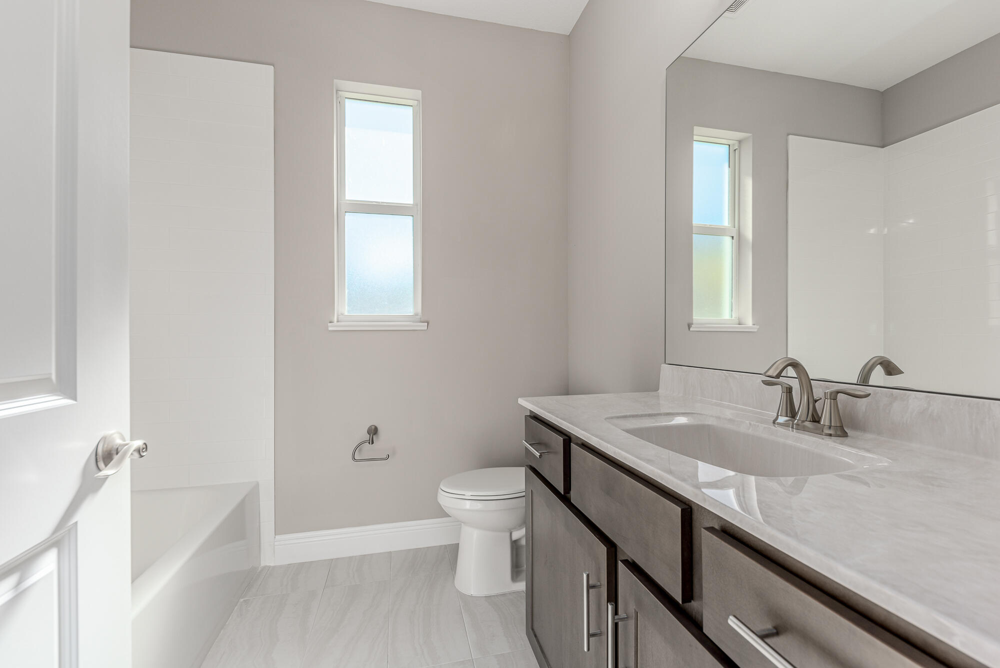 3972 Southeast Fairway West Stuart, FL 34997 - Photo 34 of 52 a bathroom with a granite countertop sink a toilet and a bathtub