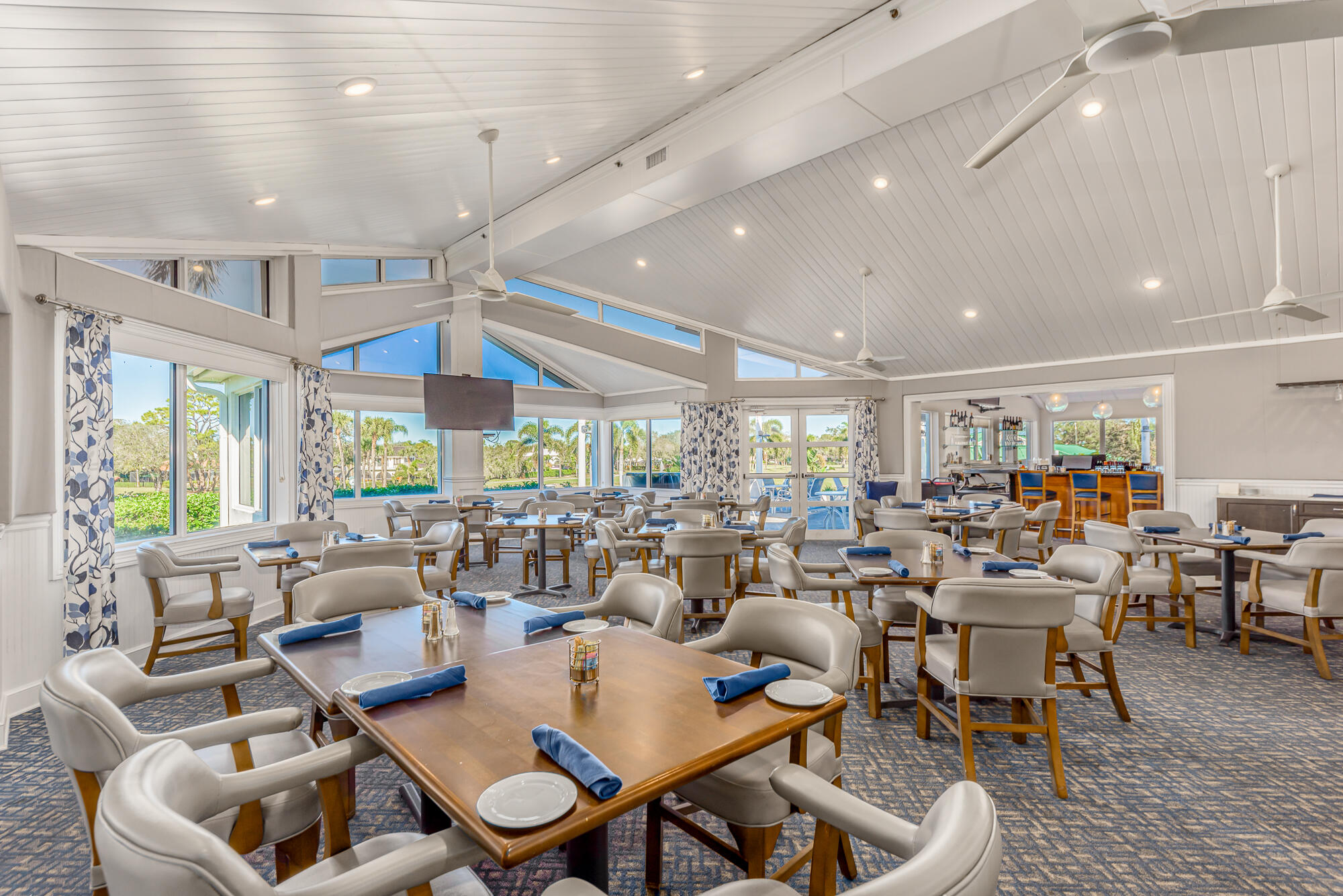 3972 Southeast Fairway West Stuart, FL 34997 - Photo 52 of 52 a room with lots of tables a large window and chairs