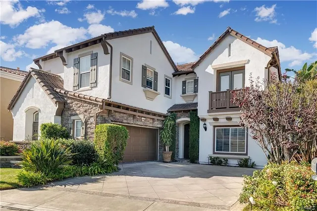 a view of a white house with large windows and a small yard