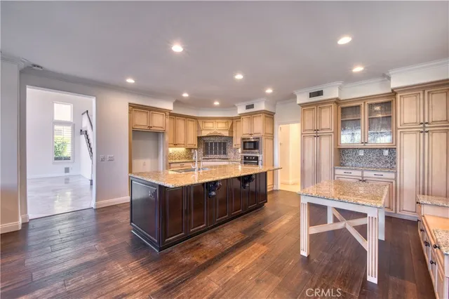 a kitchen with stainless steel appliances granite countertop a large counter top a sink and a refrigerator
