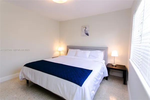 a bedroom with a bed lamp and a window