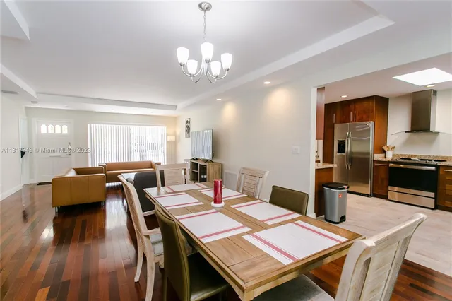 a view of a dining room with furniture a chandelier and wooden floor