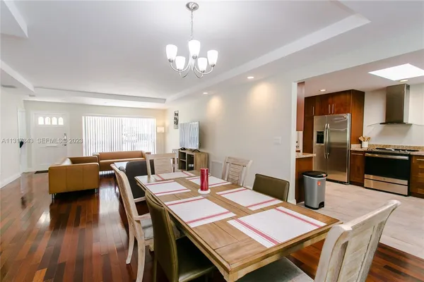 a view of a dining room with furniture a chandelier and wooden floor