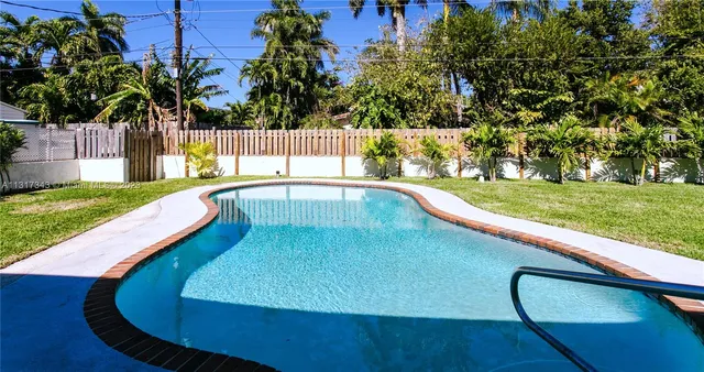 a view of a swimming pool with a yard and sitting area