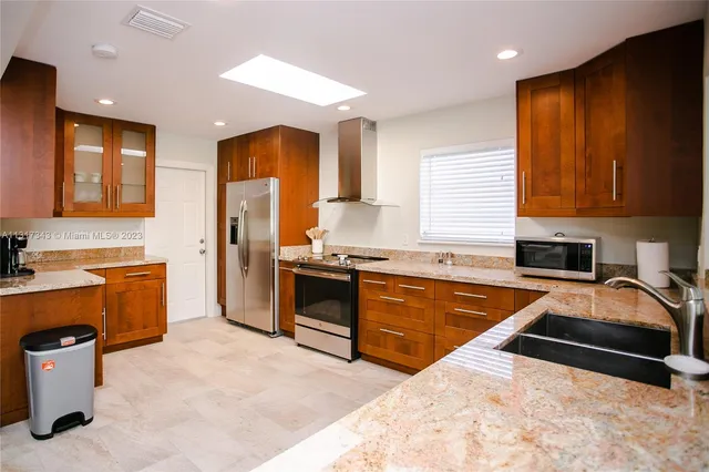 a kitchen with stainless steel appliances granite countertop a sink stove and refrigerator