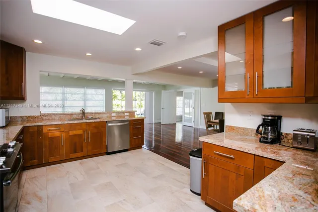 a large kitchen with stainless steel appliances granite countertop a stove a sink and a microwave