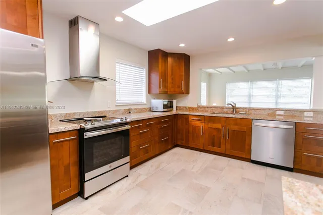a kitchen with stainless steel appliances granite countertop a stove a sink and a microwave