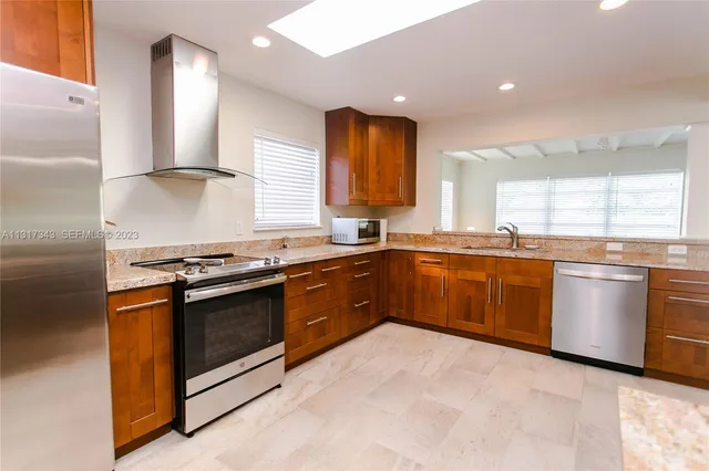 a kitchen with stainless steel appliances granite countertop a stove a sink and a microwave