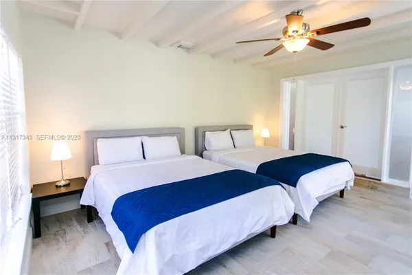 a bedroom with two beds and a ceiling fan
