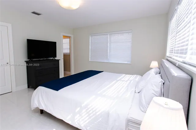 a bedroom with a bed and a flat screen tv