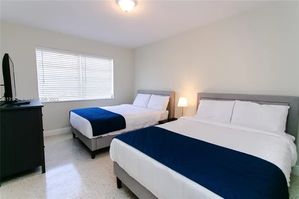 a bedroom with two beds and a couch