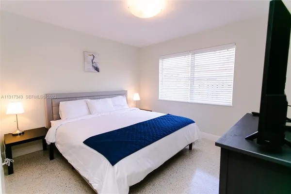 a bed sitting in a bedroom next to a window