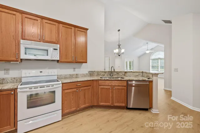 a kitchen with stainless steel appliances granite countertop a stove a sink and a microwave