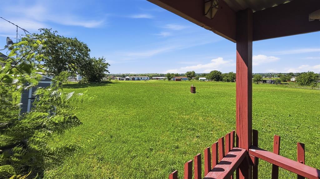 185 Private Road 4437 Rhome, TX 76078 - Photo 21 of 28 Expansive green space featuring a large grassy area, mature trees, and a distant treeline