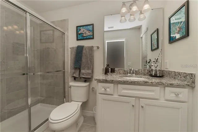 a bathroom with a granite countertop toilet sink and shower