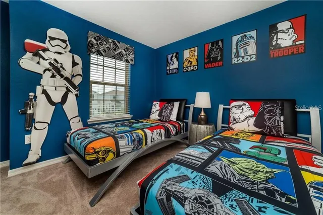 a bedroom with two beds and a painting on the wall