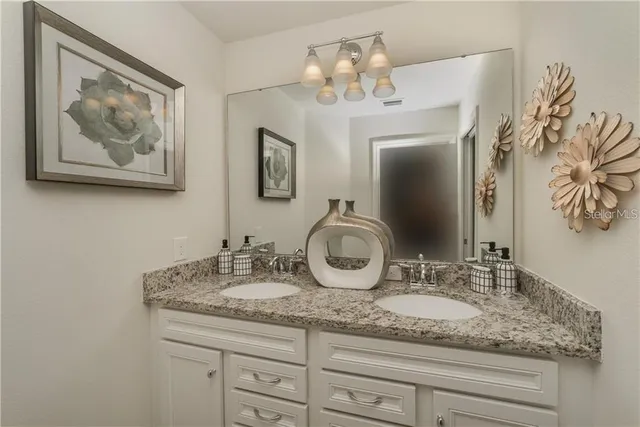 a bathroom with a granite countertop sink a mirror and vanity