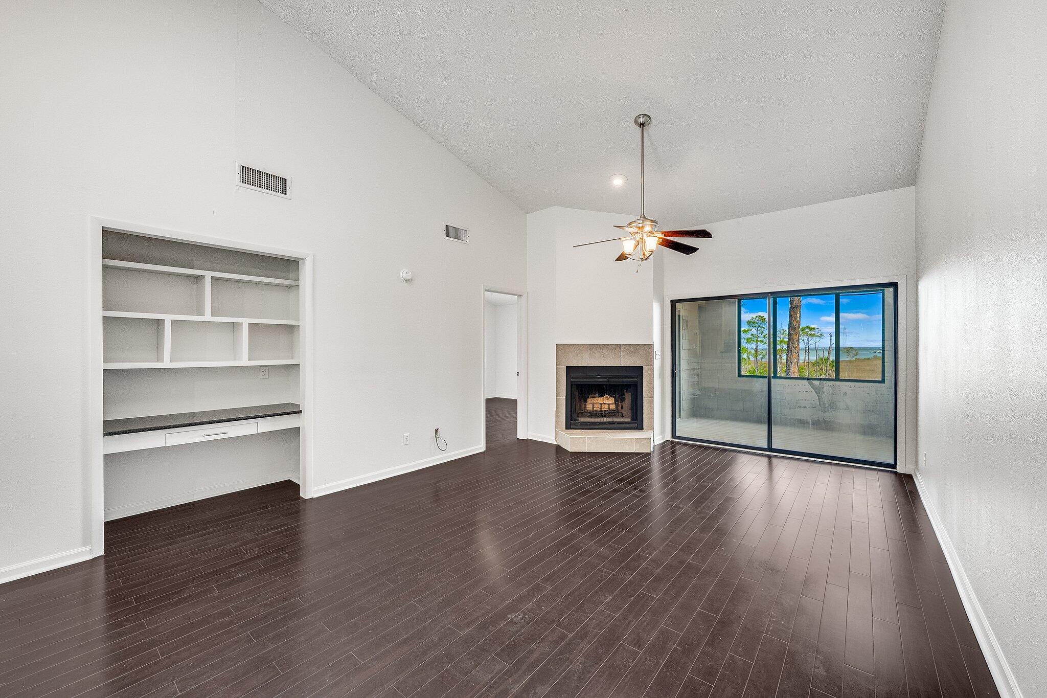 a view of an empty room with a fireplace and a window