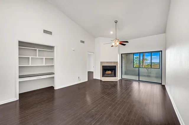 a view of an empty room with a fireplace and a window
