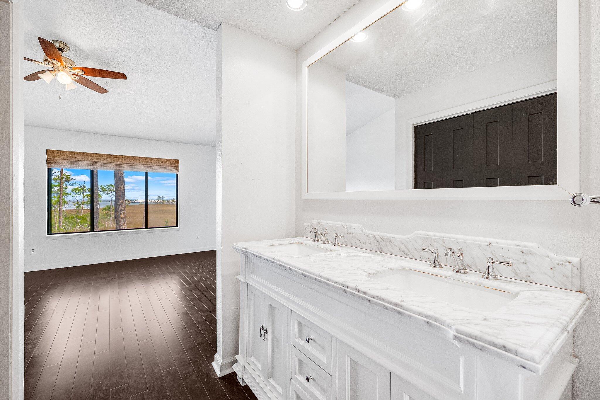8983 Heron Walk Drive, Unit 8983 Miramar Beach, FL 32550 - Photo 16 of 57 a bathroom with a granite countertop sink a large mirror and a window