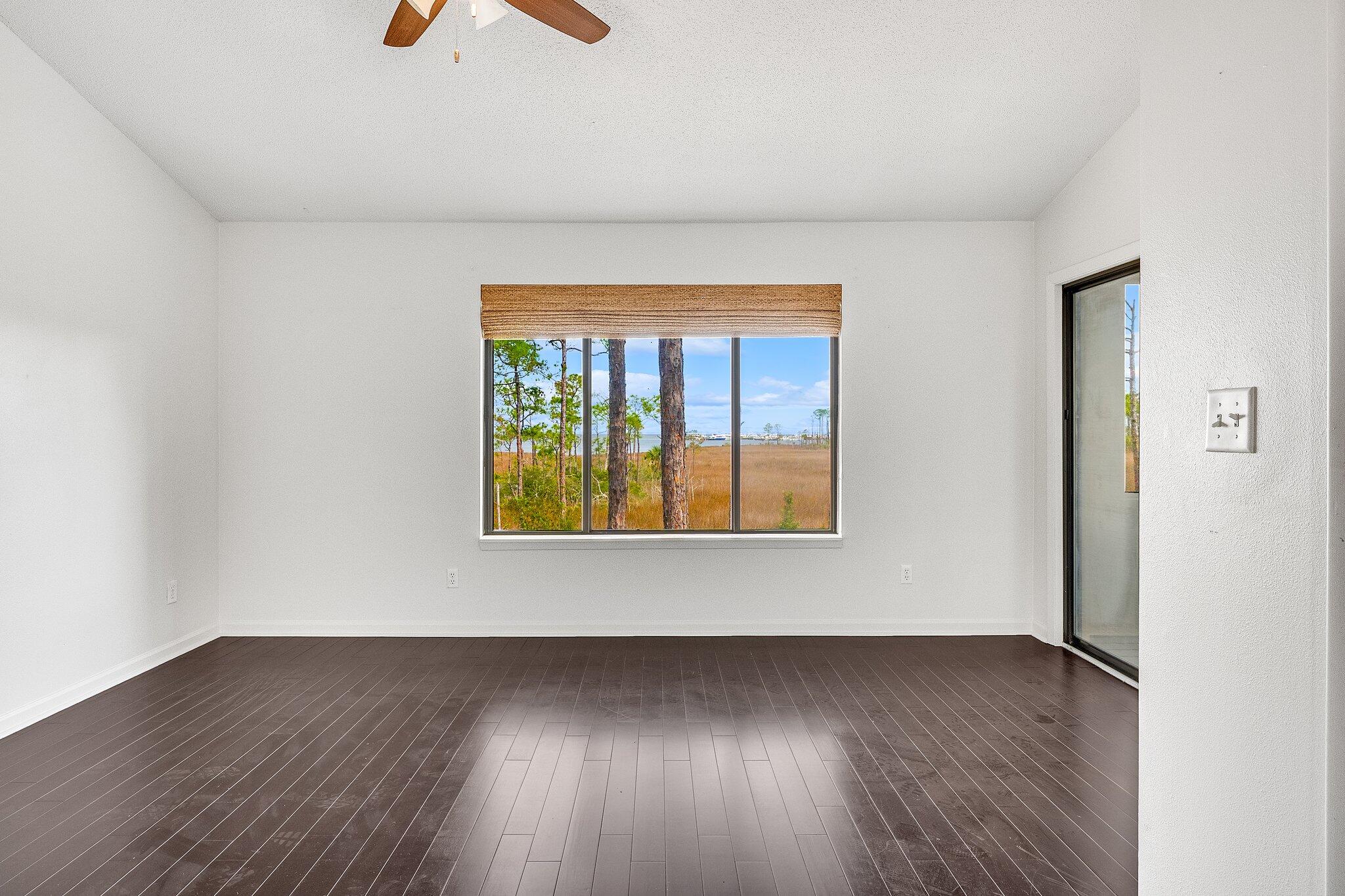 8983 Heron Walk Drive, Unit 8983 Miramar Beach, FL 32550 - Photo 17 of 57 an empty room with a window and wooden floor