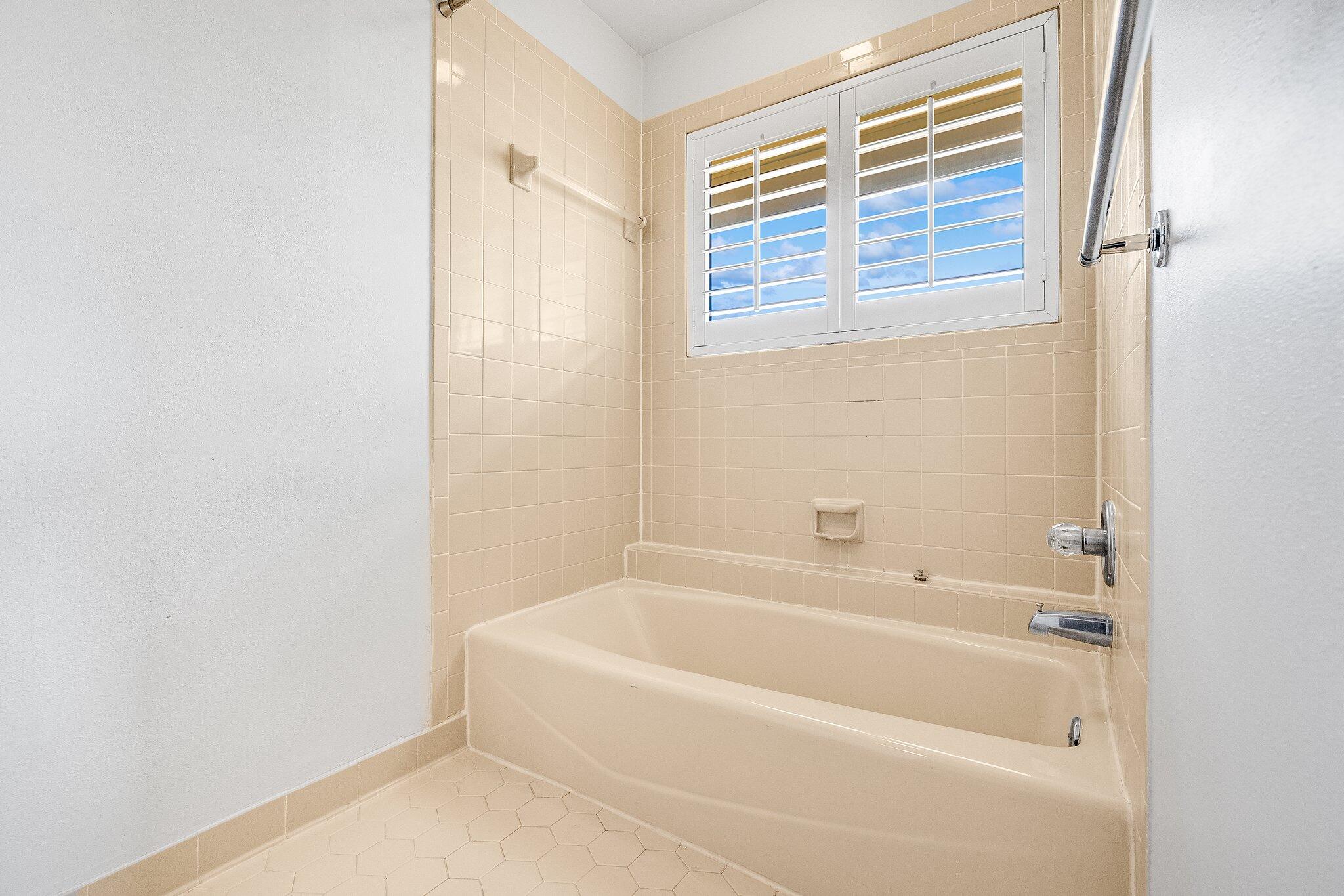 8983 Heron Walk Drive, Unit 8983 Miramar Beach, FL 32550 - Photo 21 of 57 a white bath tub sitting next to a window