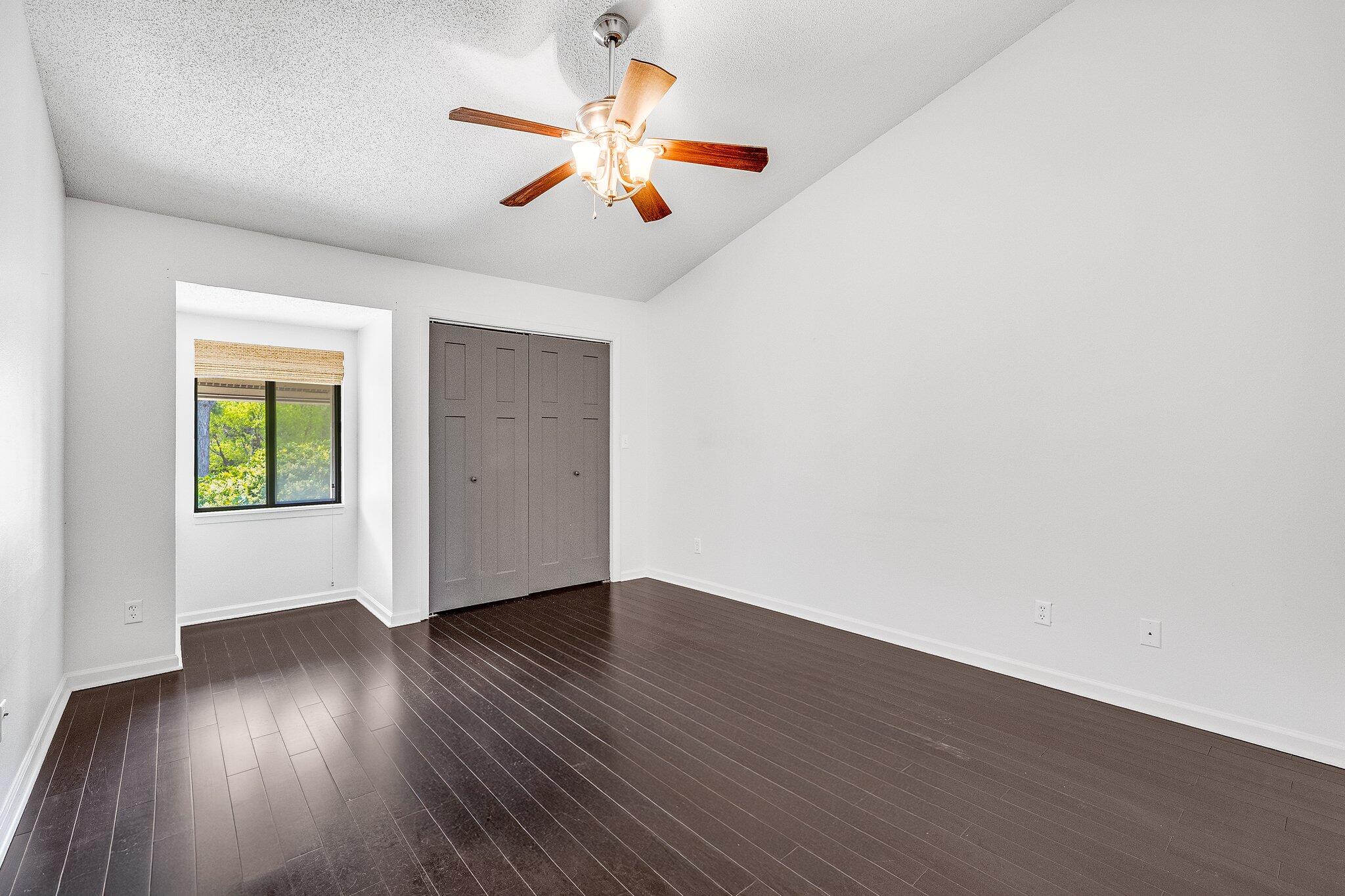 8983 Heron Walk Drive, Unit 8983 Miramar Beach, FL 32550 - Photo 22 of 57 an empty room with wooden floor and windows