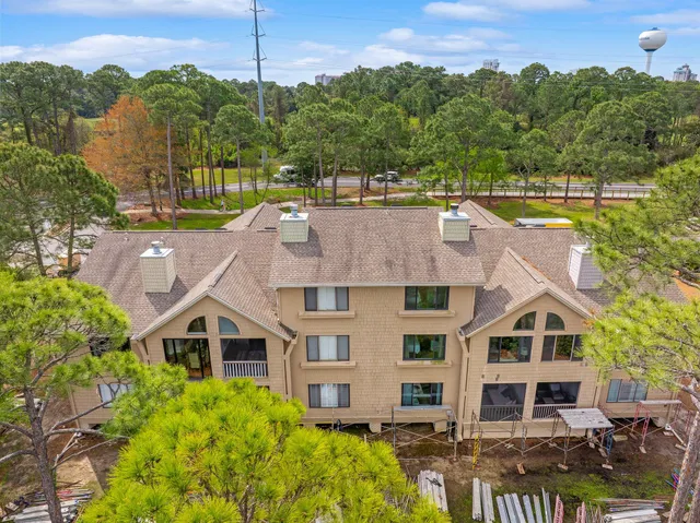 an aerial view of a house with a garden and lake view