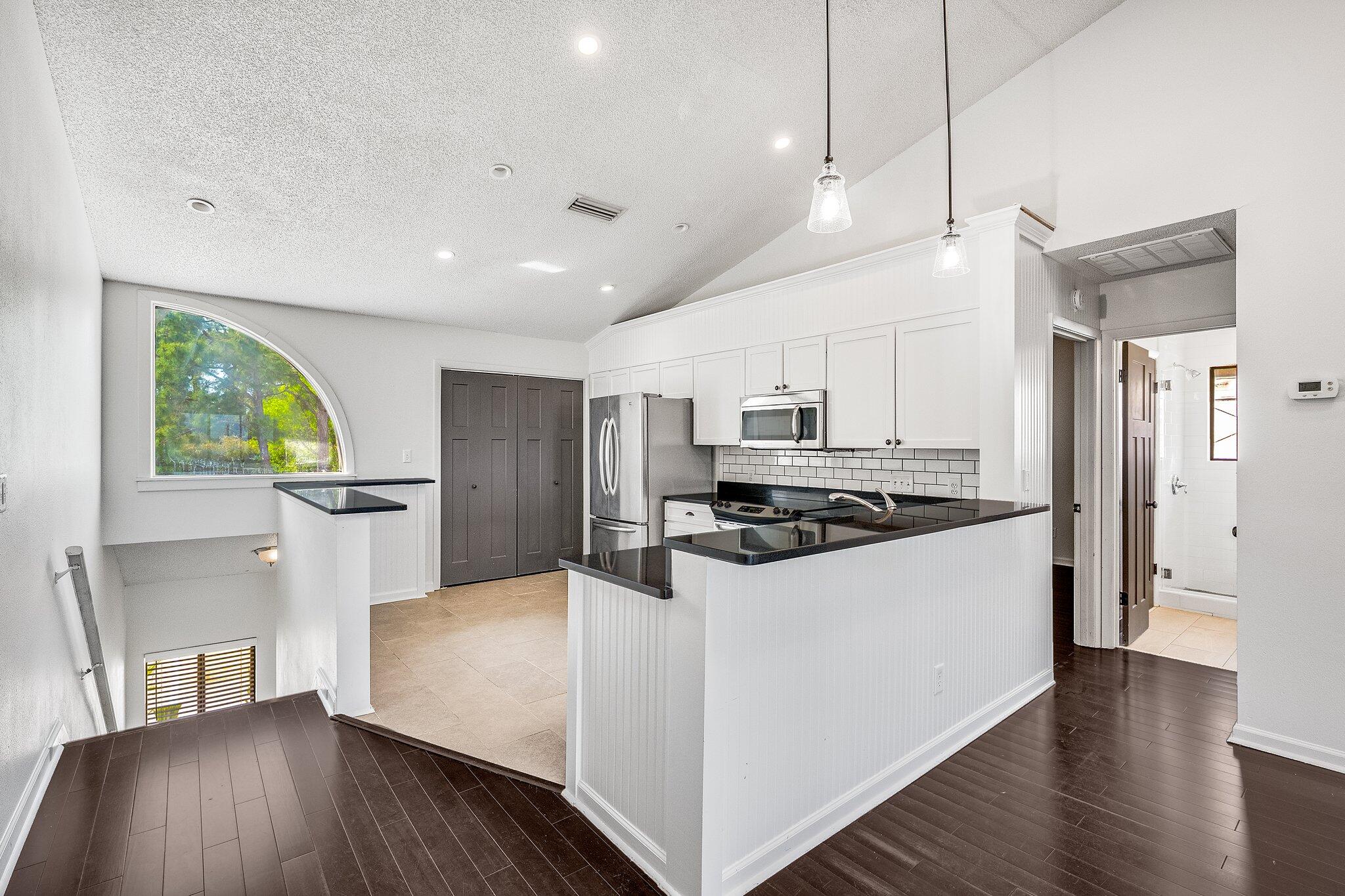 8983 Heron Walk Drive, Unit 8983 Miramar Beach, FL 32550 - Photo 6 of 57 a kitchen with stainless steel appliances a stove a refrigerator a sink a oven with wooden floor