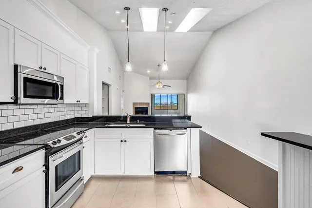 a kitchen with stainless steel appliances a stove sink microwave and cabinets