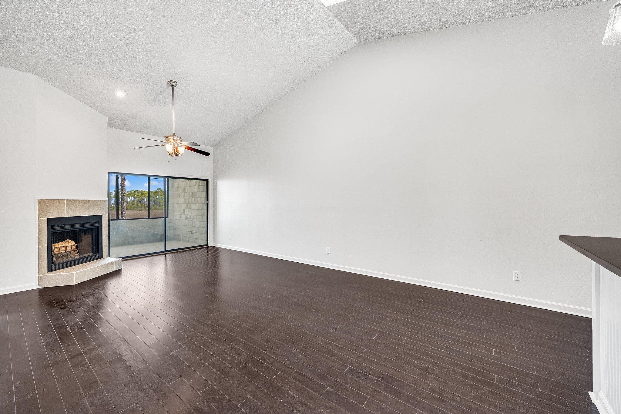 8983 Heron Walk Drive, Unit 8983 Miramar Beach, FL 32550 - Photo 9 of 57 an empty room with wooden floor fireplace and a window