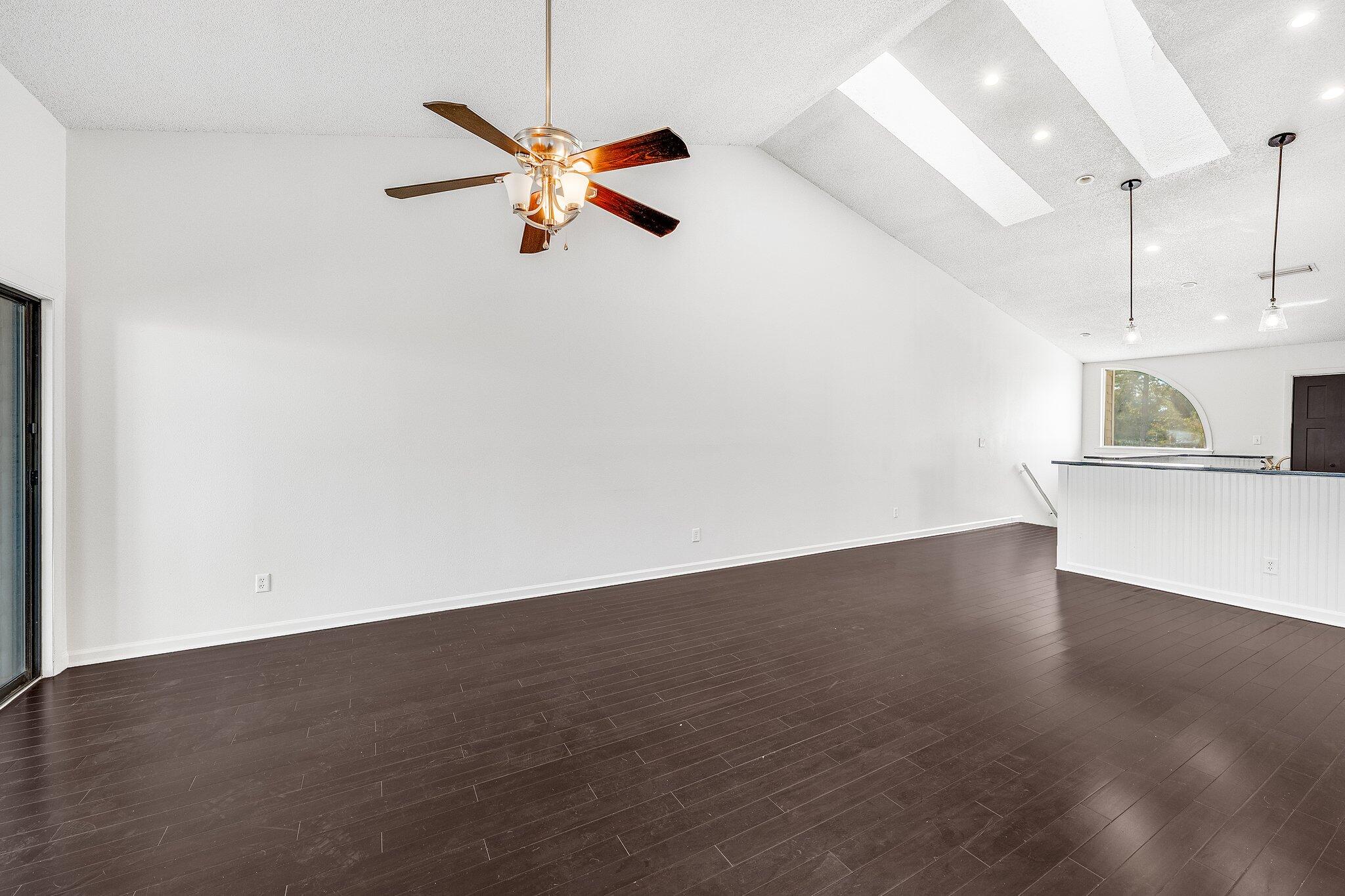 8983 Heron Walk Drive, Unit 8983 Miramar Beach, FL 32550 - Photo 10 of 57 a view of an empty room with wooden floor and a ceiling fan