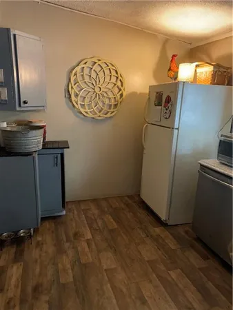 a view of a living room and kitchen with furniture wooden floor and chandelier