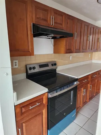 a kitchen with granite countertop a refrigerator and a stove