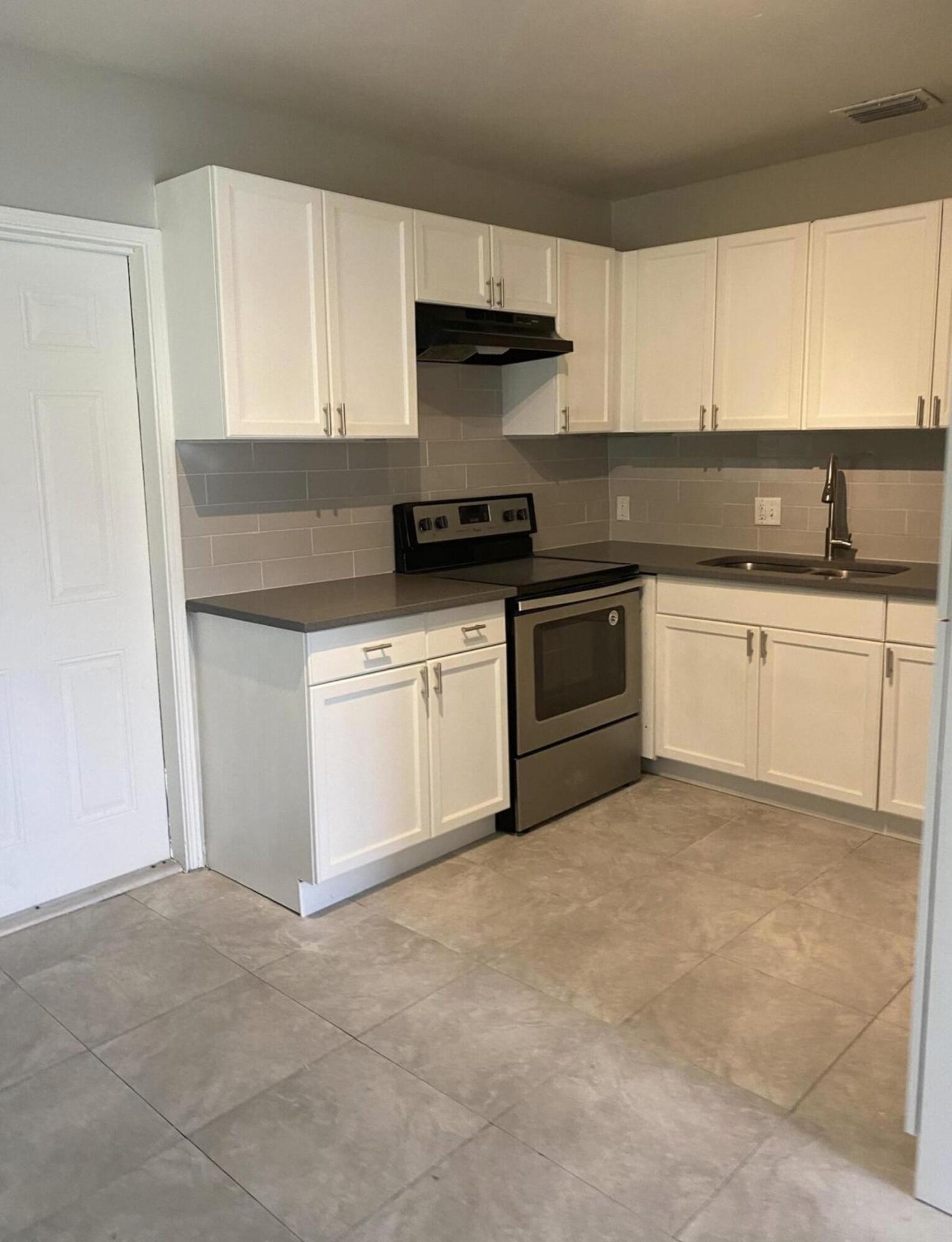 360 West 27th Street Riviera Beach, FL 33404 - Photo 3 of 5 a kitchen with granite countertop white cabinets and appliances