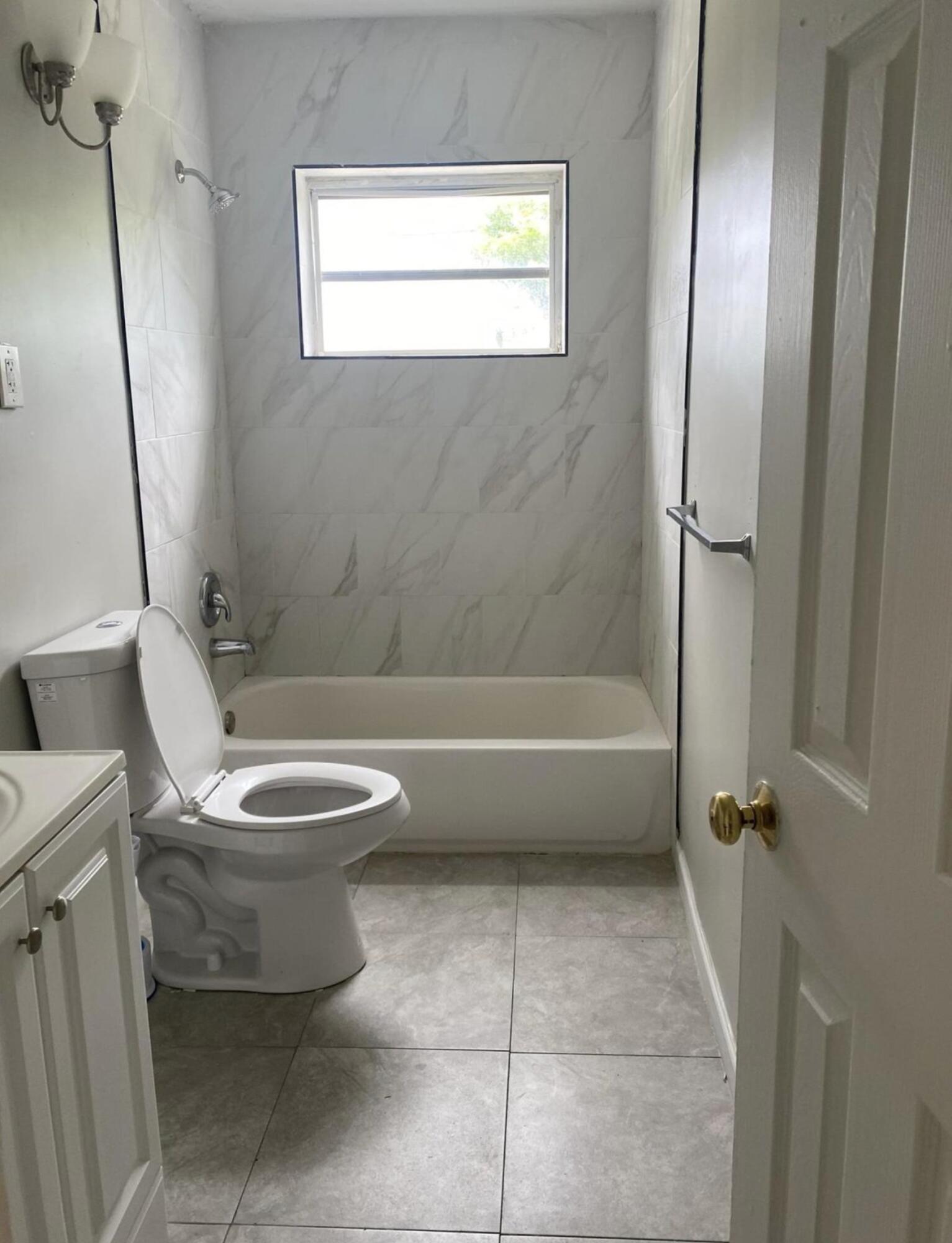 360 West 27th Street Riviera Beach, FL 33404 - Photo 4 of 5 a white toilet sitting next to a bath tub