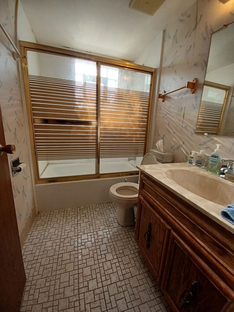 9650 Nottingham Avenue, Unit 2H Chicago Ridge, IL 60415 - Photo 8 of 13 a bathroom with a sink a toilet a mirror and shower