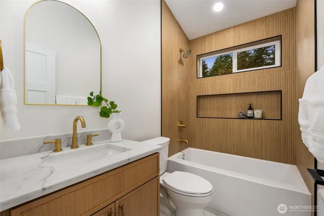 a bathroom with a granite countertop sink mirror vanity and toilet