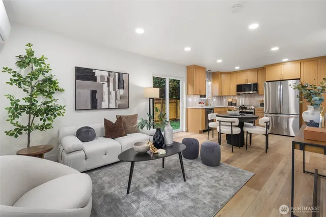 a living room with fireplace furniture and a kitchen view