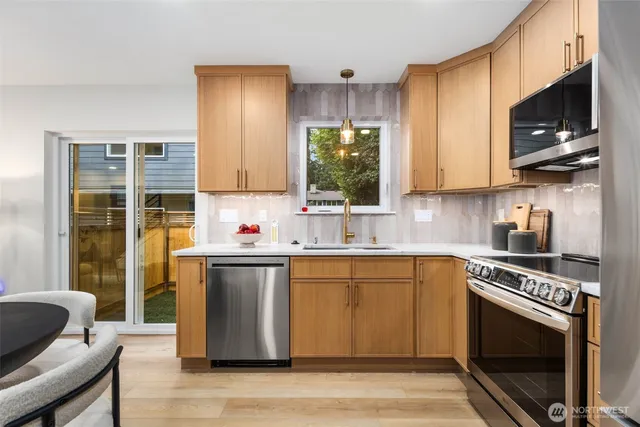 a kitchen with kitchen island granite countertop a sink cabinets and stainless steel appliances