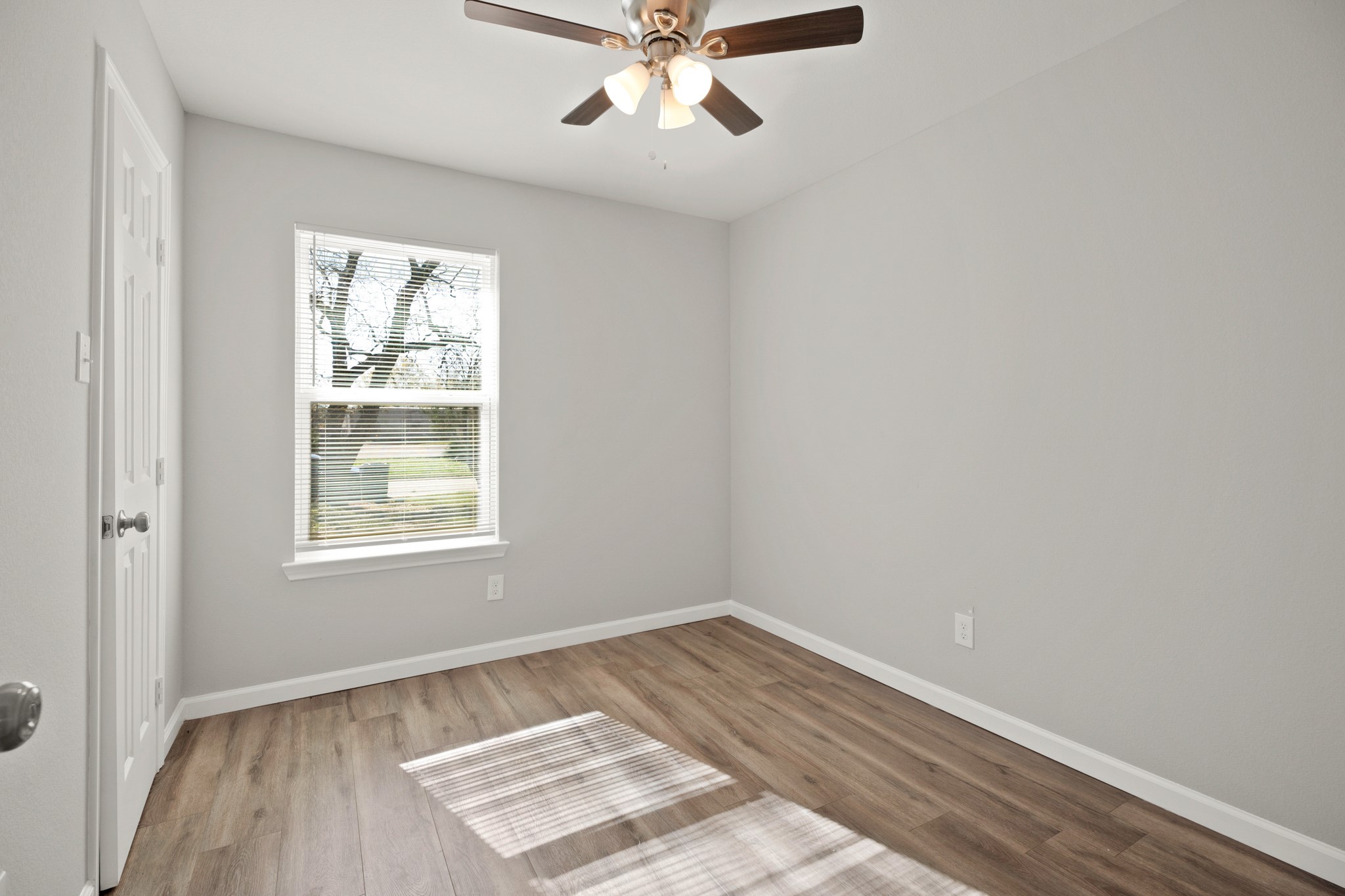 5123 Ridgeway Drive Houston, TX 77033 - Photo 12 of 21 Secondary bedroom with vinyl plank floors, a window with privacy blind, a ceiling fan, and a built-in closet.