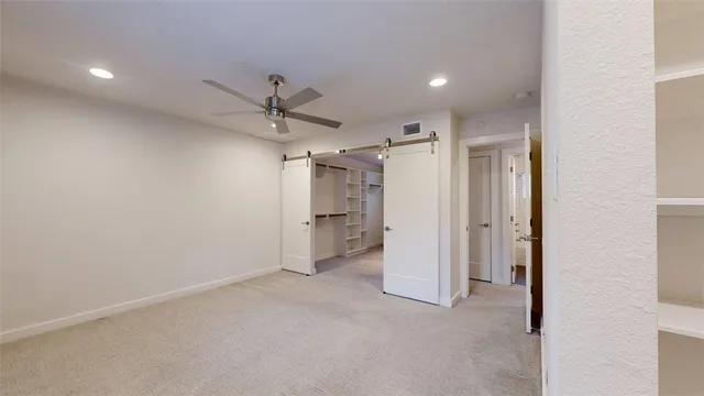 en empty room with a ceiling fan and glass door