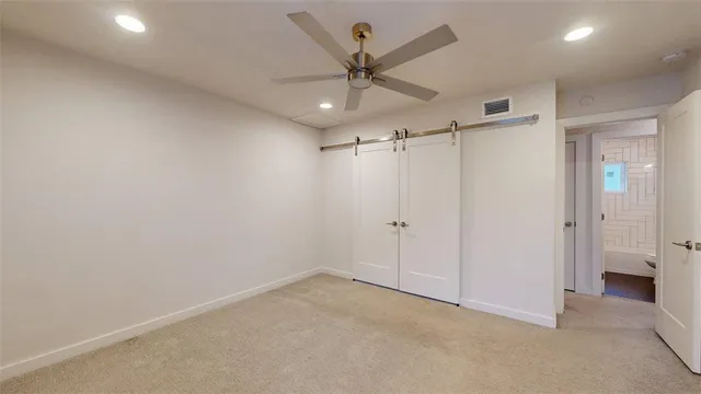 an empty room with a ceiling fan and a window